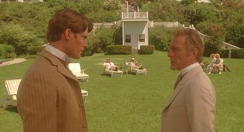 Movie still from “Somewhere in Time” (1980), directed by Jeannot Szwarc – Two men standing in the grass near a building; Medium shot, Over the shoulder angle