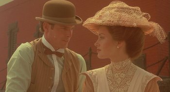Movie still from “Somewhere in Time” (1980), directed by Jeannot Szwarc – A man and a woman wearing hats and a suit; Close Up shot, Over the shoulder angle