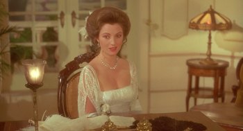 Movie still from “Somewhere in Time” (1980), directed by Jeannot Szwarc – A woman sitting at a table wearing a white dress; Close Up shot, Over the shoulder angle