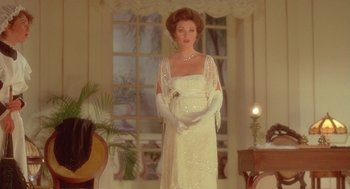 Movie still from “Somewhere in Time” (1980), directed by Jeannot Szwarc – A woman in a white dress standing in a living room; Medium shot, Low angle