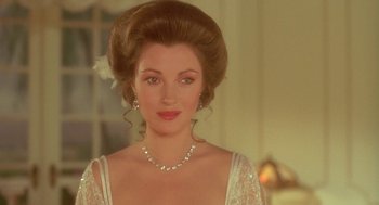 Movie still from “Somewhere in Time” (1980), directed by Jeannot Szwarc – A woman in a white dress and a pearl necklace; Close Up shot, Over the shoulder angle