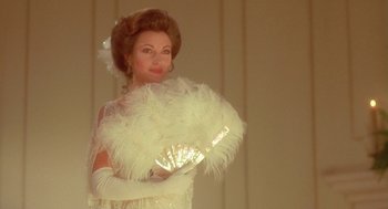 Movie still from “Somewhere in Time” (1980), directed by Jeannot Szwarc – A woman in a white dress holding a white fan; Close Up shot, Low angle
