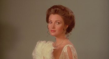 Movie still from “Somewhere in Time” (1980), directed by Jeannot Szwarc – A beautiful woman in a white dress and a feather boa; Close Up shot, Low angle