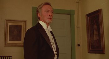 Movie still from “Somewhere in Time” (1980), directed by Jeannot Szwarc – A man in a tuxedo standing in front of a green door; Close Up shot, Low angle