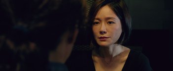 A woman with short black hair is looking at a man