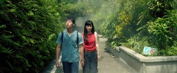 A man and a woman holding hands while walking down a sidewalk