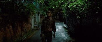 A man standing in the middle of an alleyway at night