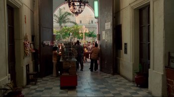 Movie still from “Sorcerer” (1977), directed by William Friedkin – A group of people walking through an archway; Extreme Wide shot, Over the shoulder angle