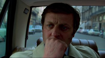 Movie still from “Sorcerer” (1977), directed by William Friedkin – A person sitting in a car with his hand to his face; Close Up shot, High angle