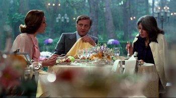 Movie still from “Sorcerer” (1977), directed by William Friedkin – A group of people sitting at a table with food; Medium shot, Over the shoulder angle