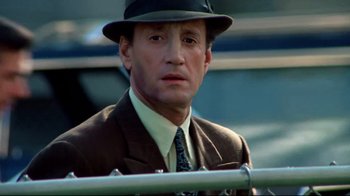 Movie still from “Sorcerer” (1977), directed by William Friedkin – A person wearing a suit and a hat; Close Up shot, Low angle