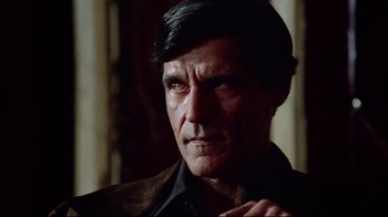 Movie still from “Sorcerer” (1977), directed by William Friedkin – A person wearing a suit and tie; Close Up shot, Low angle