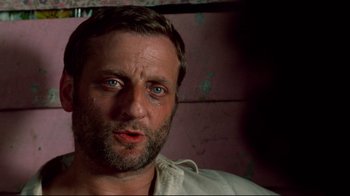 Movie still from “Sorcerer” (1977), directed by William Friedkin – A person wearing a white shirt; Close Up shot, Over the shoulder angle