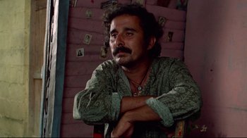 Movie still from “Sorcerer” (1977), directed by William Friedkin – A man sitting in a chair with his arms crossed; Close Up shot, Low angle