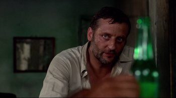 Movie still from “Sorcerer” (1977), directed by William Friedkin – A person sitting at a table; Close Up shot, Low angle