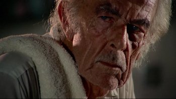Movie still from “Sorcerer” (1977), directed by William Friedkin – An older man with a towel around his neck; Extreme Close Up shot, Low angle