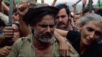 Movie still from “Sorcerer” (1977), directed by William Friedkin – A man with a beard and a hat is being hugged by a man with a beard and a hat; Close Up shot, Over the shoulder angle