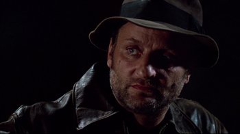 Movie still from “Sorcerer” (1977), directed by William Friedkin – A person wearing a hat and jacket; Close Up shot, Low angle