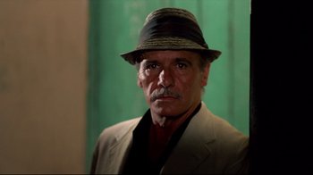 Movie still from “Sorcerer” (1977), directed by William Friedkin – A man wearing a suit and a hat; Close Up shot, Low angle