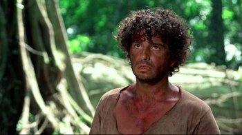 Movie still from “Sorcerer” (1977), directed by William Friedkin – A person wearing a shirt with blood all over his face; Close Up shot, Over the shoulder angle