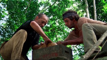 Movie still from “Sorcerer” (1977), directed by William Friedkin – Two men working together on a wooden box; Wide shot, Low angle