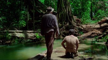 Movie still from “Sorcerer” (1977), directed by William Friedkin – Two men standing next to a body of water; Wide shot, Low angle