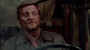 Movie still from “Sorcerer” (1977), directed by William Friedkin – A person with a knife in his face; Close Up shot, Over the shoulder angle