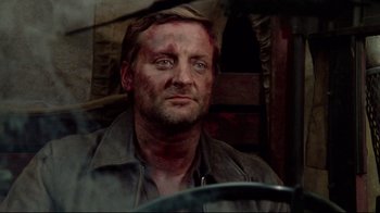 Movie still from “Sorcerer” (1977), directed by William Friedkin – A person wearing a shirt; Close Up shot, High angle