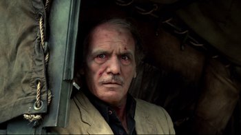 Movie still from “Sorcerer” (1977), directed by William Friedkin – An old man with a beard and mustache looking at the camera; Close Up shot, Low angle