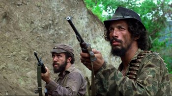 Movie still from “Sorcerer” (1977), directed by William Friedkin – Two men in camouflage holding guns in their hands; Medium shot, Low angle