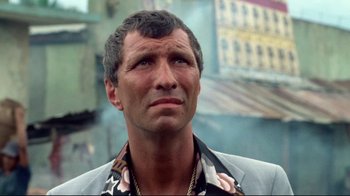 Movie still from “Sorcerer” (1977), directed by William Friedkin – A person wearing a suit and tie; Close Up shot, Low angle