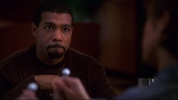 Movie still from “Soul Food” (1997), directed by George Tillman Jr. – A person sitting at a table; Close Up shot, High angle