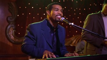 Movie still from “Soul Food” (1997), directed by George Tillman Jr. – A man in a blue suit is playing the piano; Medium shot, High angle