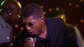 Movie still from “Soul Food” (1997), directed by George Tillman Jr. – A person singing into a microphone; Close Up shot, Low angle