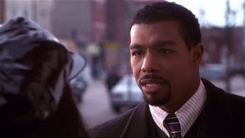 Movie still from “Soul Food” (1997), directed by George Tillman Jr. – A person wearing a suit and tie; Close Up shot, Over the shoulder angle