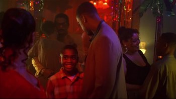 Movie still from “Soul Food” (1997), directed by George Tillman Jr. – A group of people in a room with lights; Medium shot, Over the shoulder angle
