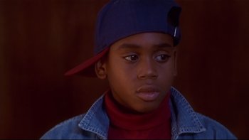 Movie still from “Soul Food” (1997), directed by George Tillman Jr. – A young boy wearing a blue hat and a red shirt; Close Up shot, High angle