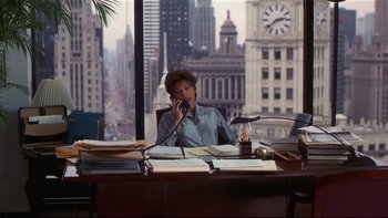Movie still from “Soul Food” (1997), directed by George Tillman Jr. – A woman sitting at a desk talking on the phone; Wide shot, High angle