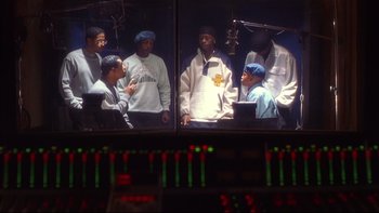 Movie still from “Soul Food” (1997), directed by George Tillman Jr. – A group of men standing in front of a monitor; Medium shot, High angle