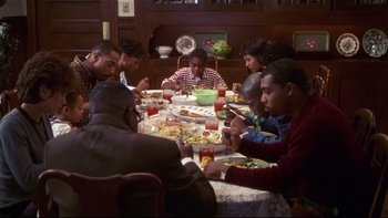Movie still from “Soul Food” (1997), directed by George Tillman Jr. – A group of people sitting around a table eating food; Medium shot, High angle