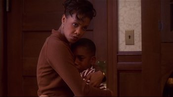 Movie still from “Soul Food” (1997), directed by George Tillman Jr. – A woman holding a child in her arms; Medium shot, High angle