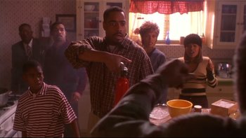 Movie still from “Soul Food” (1997), directed by George Tillman Jr. – A group of people standing around a table; Medium shot, Over the shoulder angle