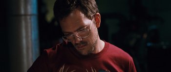 Movie still from “Sound of Noise” (2010), directed by Ola Simonsson – A person wearing glasses and a red shirt; Close Up shot, Low angle
