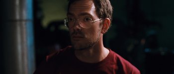 Movie still from “Sound of Noise” (2010), directed by Ola Simonsson – A person wearing glasses and a red shirt; Close Up shot, High angle