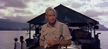 Movie still from “South Pacific” (1958), directed by Joshua Logan – A man wearing a hat and holding a cigarette; Medium shot, Low angle
