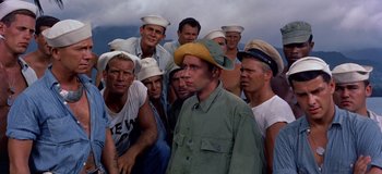 Movie still from “South Pacific” (1958), directed by Joshua Logan – A group of men wearing hats and standing in a row; Medium shot, High angle