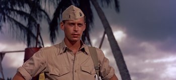 Movie still from “South Pacific” (1958), directed by Joshua Logan – A man in a military uniform with a palm tree in the background; Close Up shot, Low angle