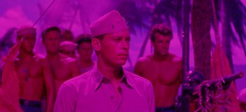 Movie still from “South Pacific” (1958), directed by Joshua Logan – A group of men standing next to each other in a purple room; Medium shot, Low angle