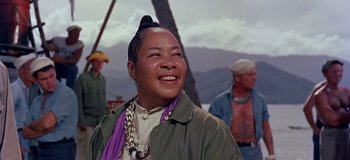 Movie still from “South Pacific” (1958), directed by Joshua Logan – An asian man with a long black hair and a purple scarf; Close Up shot, Low angle