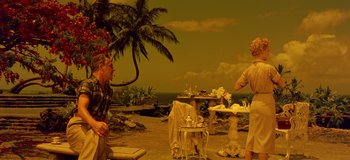 Movie still from “South Pacific” (1958), directed by Joshua Logan – A couple of people that are standing in the dirt; Wide shot, High angle